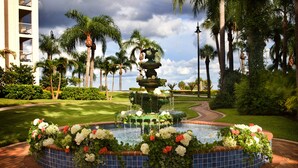 A circular fountain with tiered water features, surrounded by a tiled border and decorated with white and red flowers. - Safety Harbor Resort & Spa Trademark Collection by Wyndham (Safety Harbor)