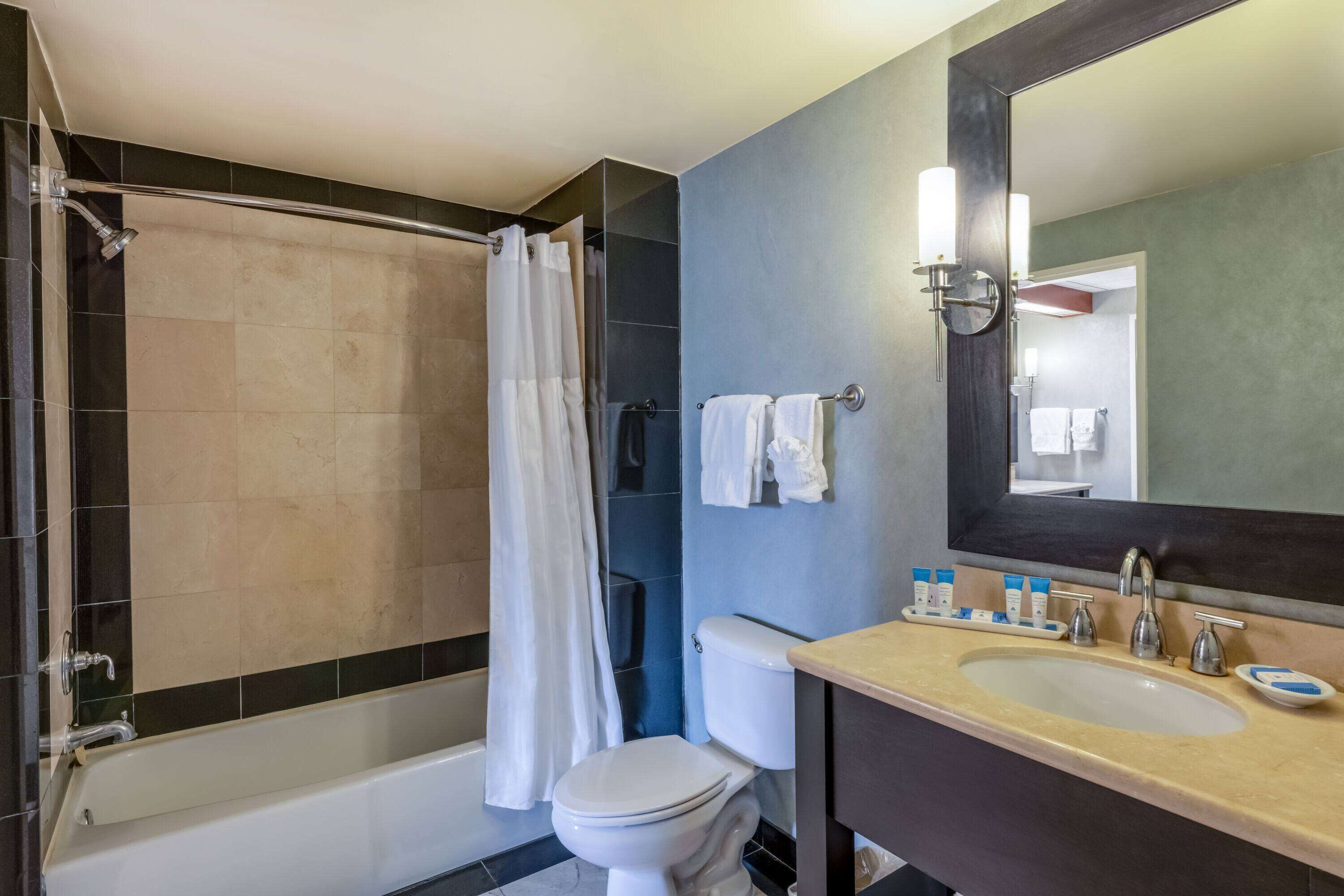 A bathroom with a bathtub, toilet, and sink.