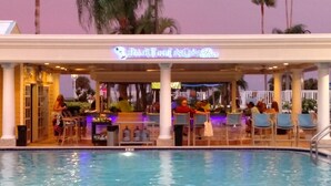 A poolside bar area with a neon sign reading "PARTHENON Bar" and several people seated at tables. - Safety Harbor Resort & Spa Trademark Collection by Wyndham (Safety Harbor)