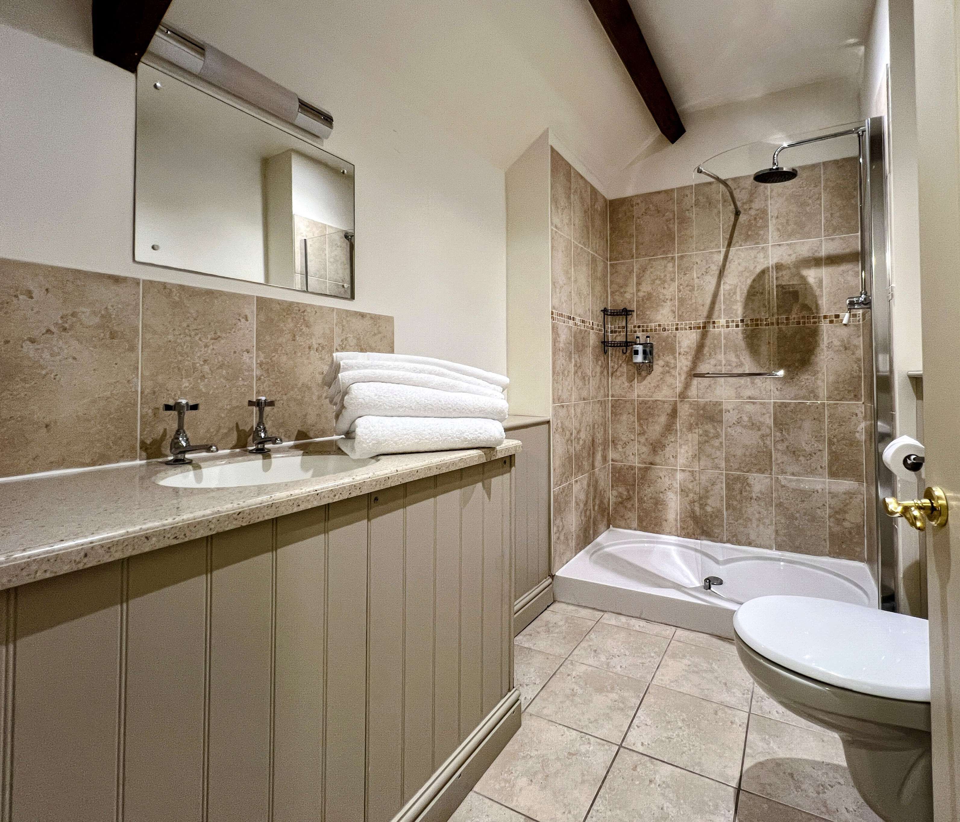 A bathroom with a bathtub, a shower, and a sink with a mirror above it.