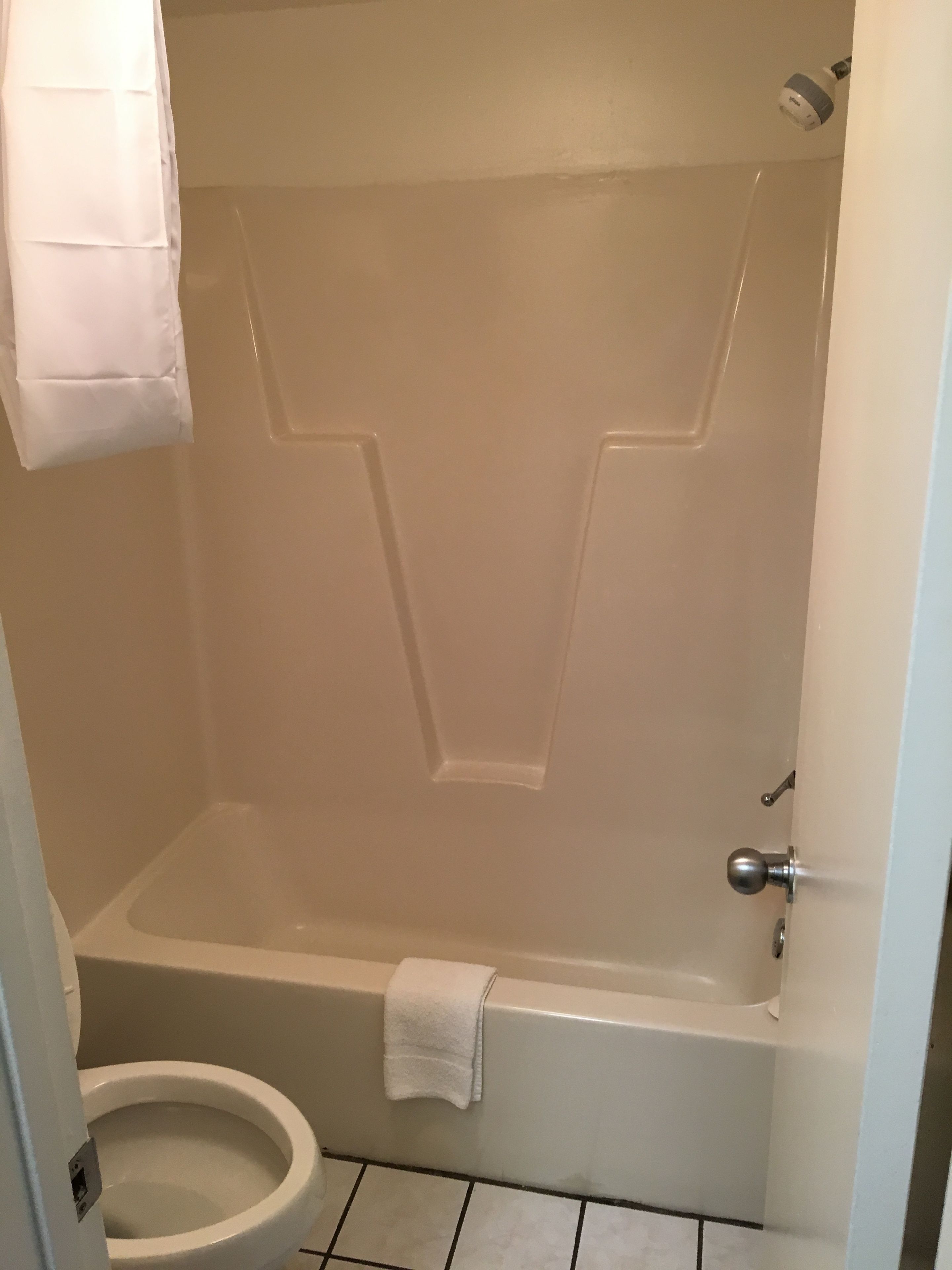 Un baño con una bañera blanca, un inodoro y una zona de ducha.