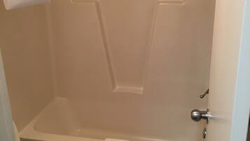Un baño con una bañera blanca, un inodoro y una zona de ducha.