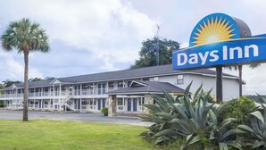 Et Days Inn motel med et stort skilt, en toetages bygning og et græsstykke med beplantning.
