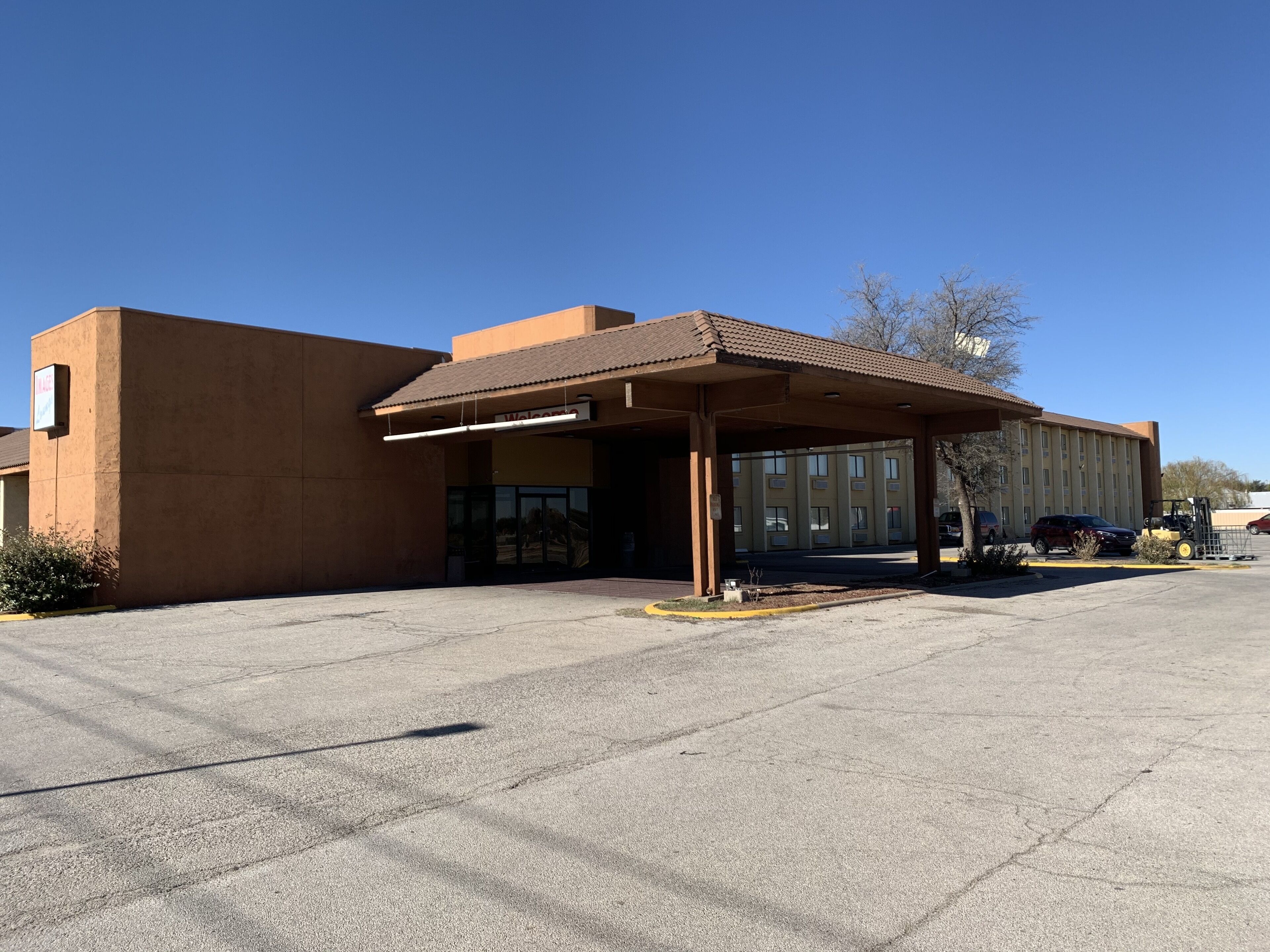 Un bâtiment doté d’une entrée abritée et d’un parking.