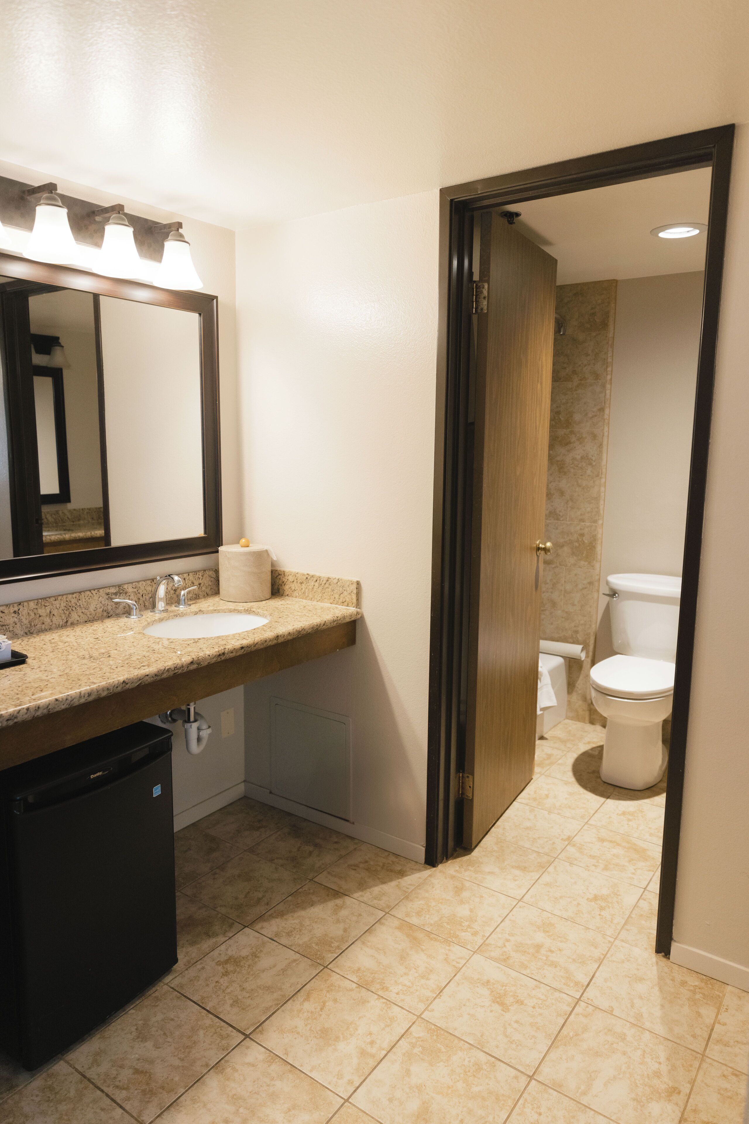 A bathroom with a sink, mirror, and toilet.