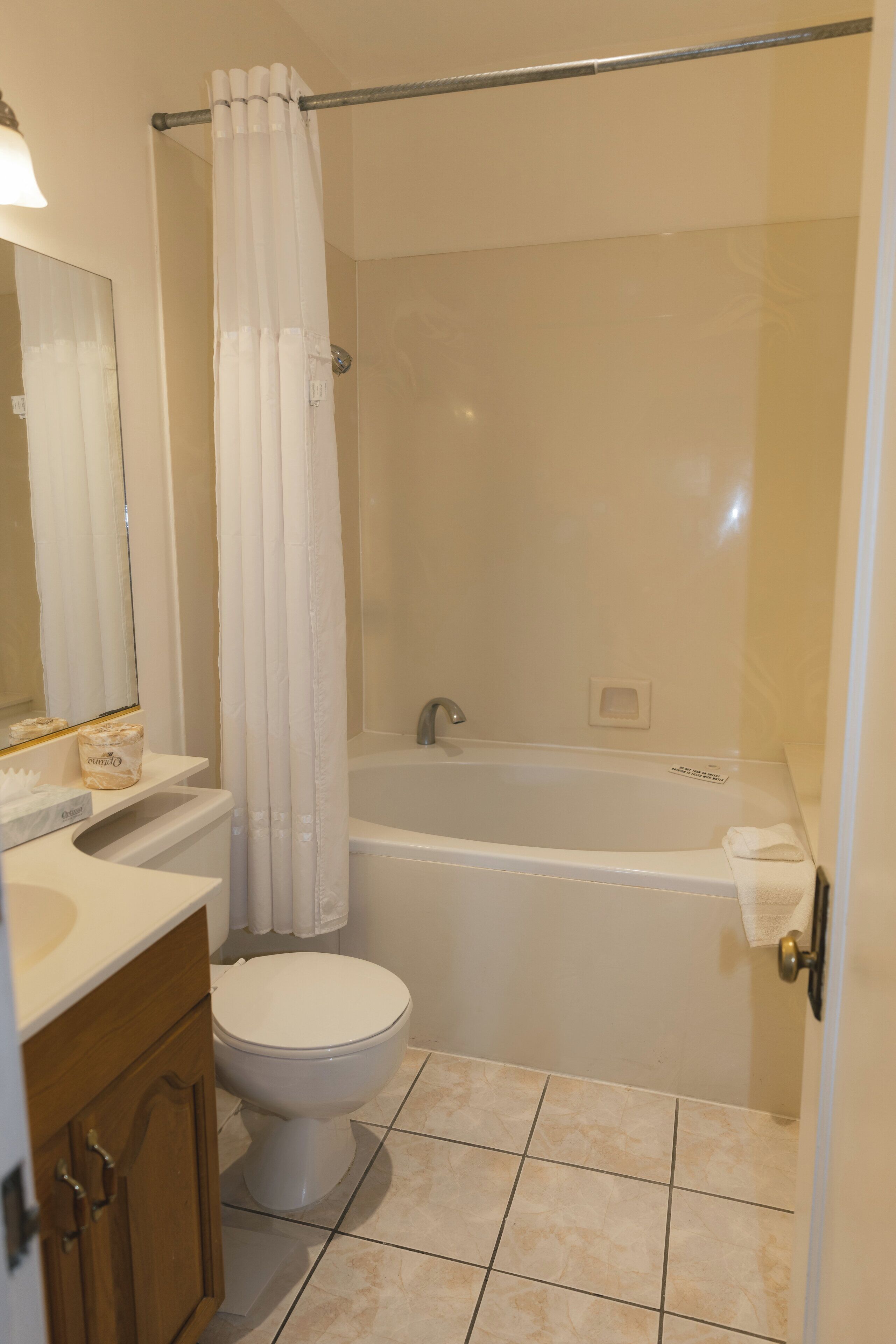 A bathroom with a toilet, sink, and bathtub.
