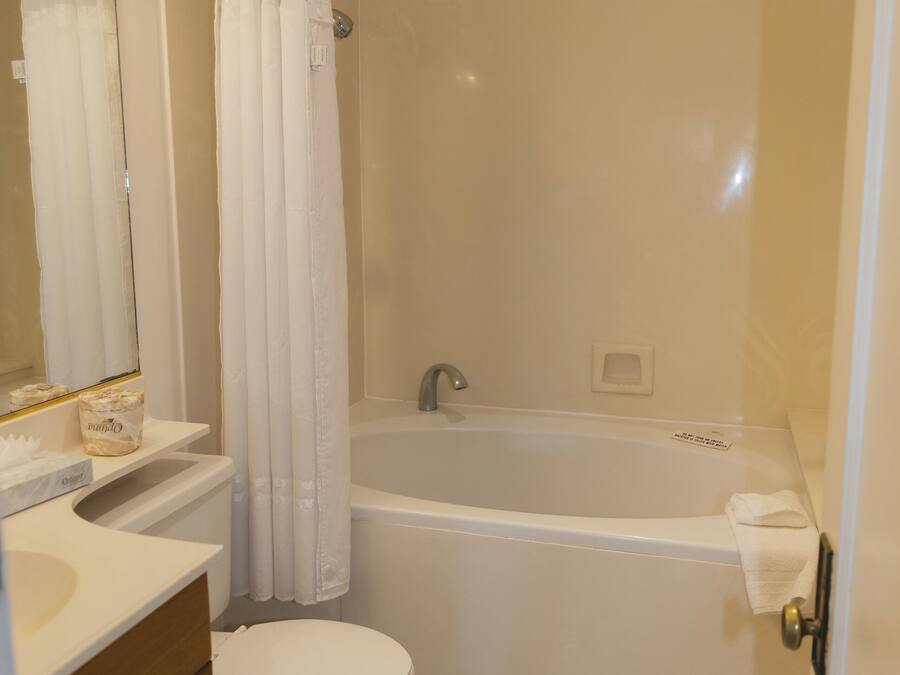 A bathroom with a toilet, sink, and bathtub.