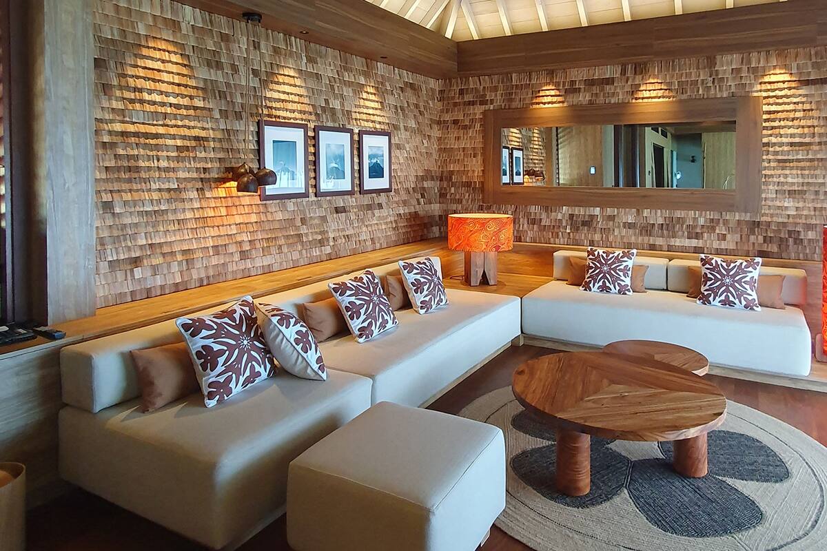 A modern living room with a sectional sofa, a wooden coffee table, and a patterned rug.