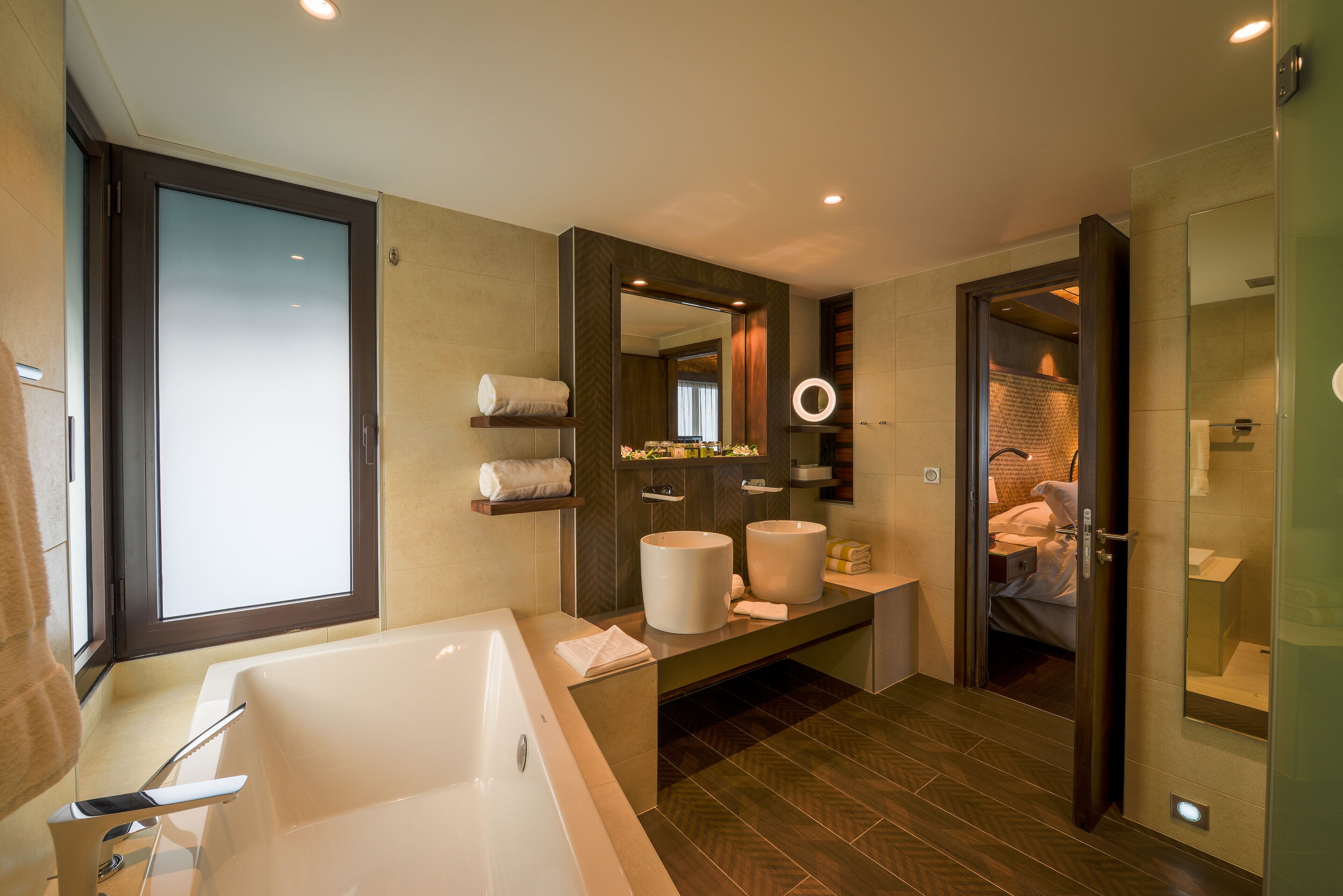A modern bathroom with a large bathtub, a vanity with a mirror, and a shower area.