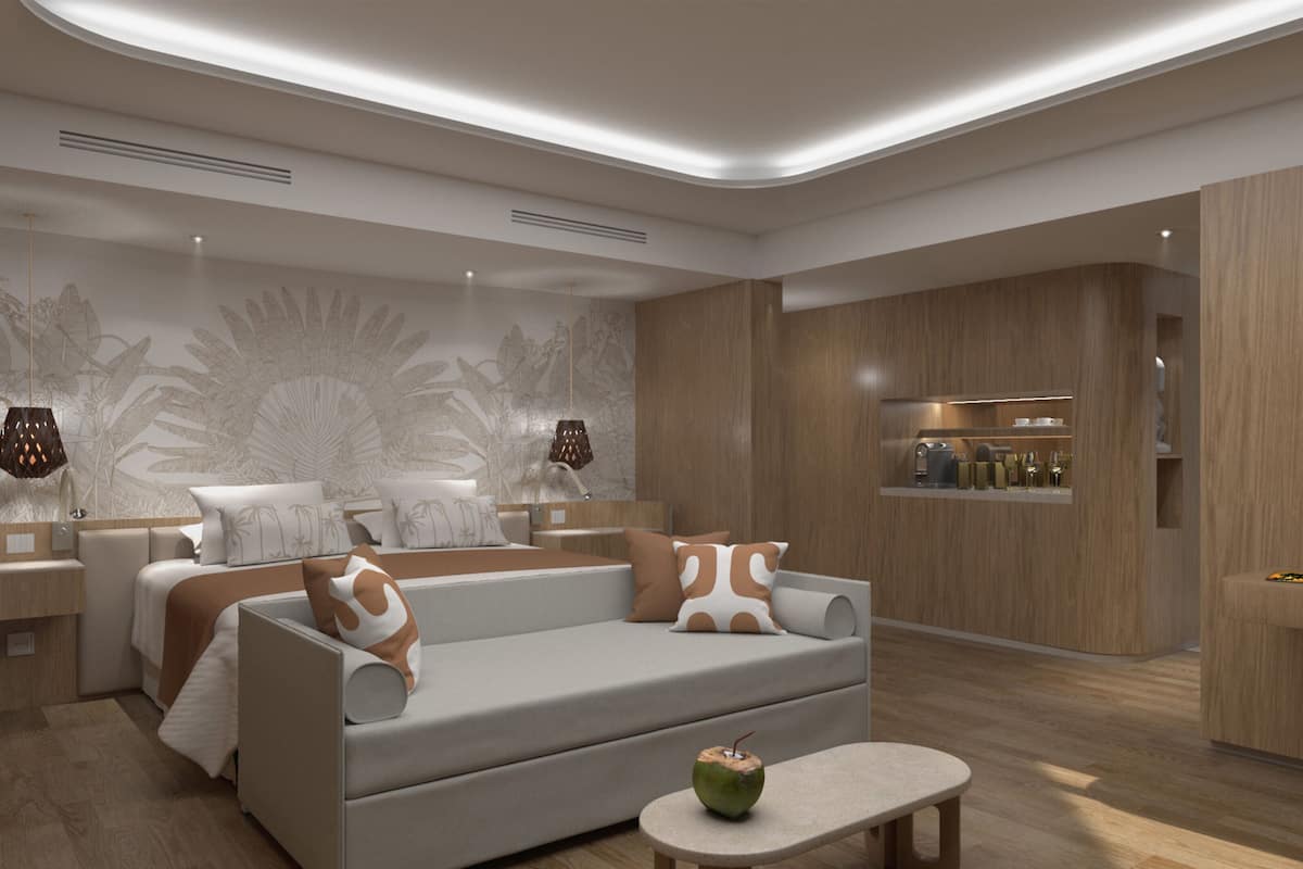 A modern hotel room with a sofa, a small table, and a minibar.