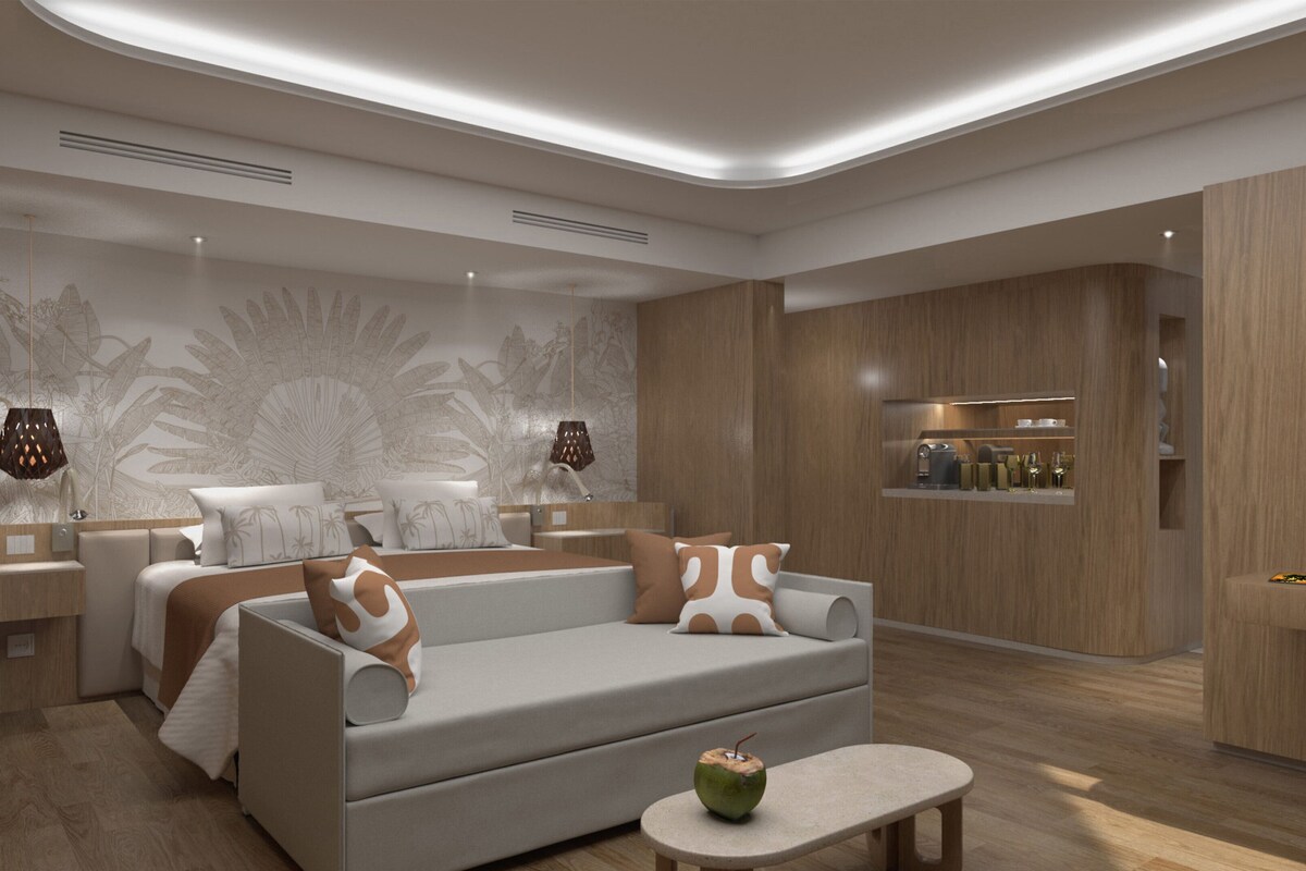 Une chambre d’hôtel moderne équipée d’un canapé, d’une petite table et d’un mini-bar.