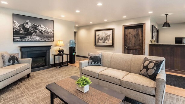 A living room with two sofas, a coffee table, a fireplace, and a large framed picture on the wall.