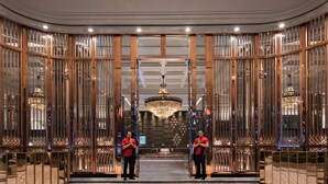 A grand lobby with a checkered floor, a chandelier, and two uniformed staff members. - Bangkok Marriott Marquis Queen’s Park (Bangkok)