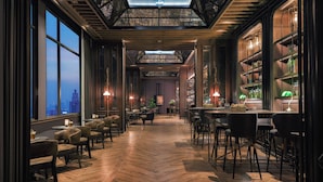 A restaurant with wooden floors, bar seating, and large windows overlooking a cityscape. - Bangkok Marriott Marquis Queen’s Park (Bangkok)