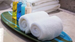 A green tray with white towels and bottles of bath products. - Keystone Boardwalk Inn and Suites (Keystone)