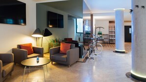Un vestíbulo moderno con asientos, una bicicleta y una zona de bar.
