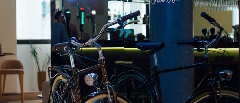 A bicycle parked in front of a bar named "BICICLETA Food Ride" with a neon sign.