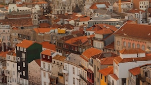 Una zona urbana densamente poblada con diversos estilos arquitectónicos y una grúa a lo lejos.