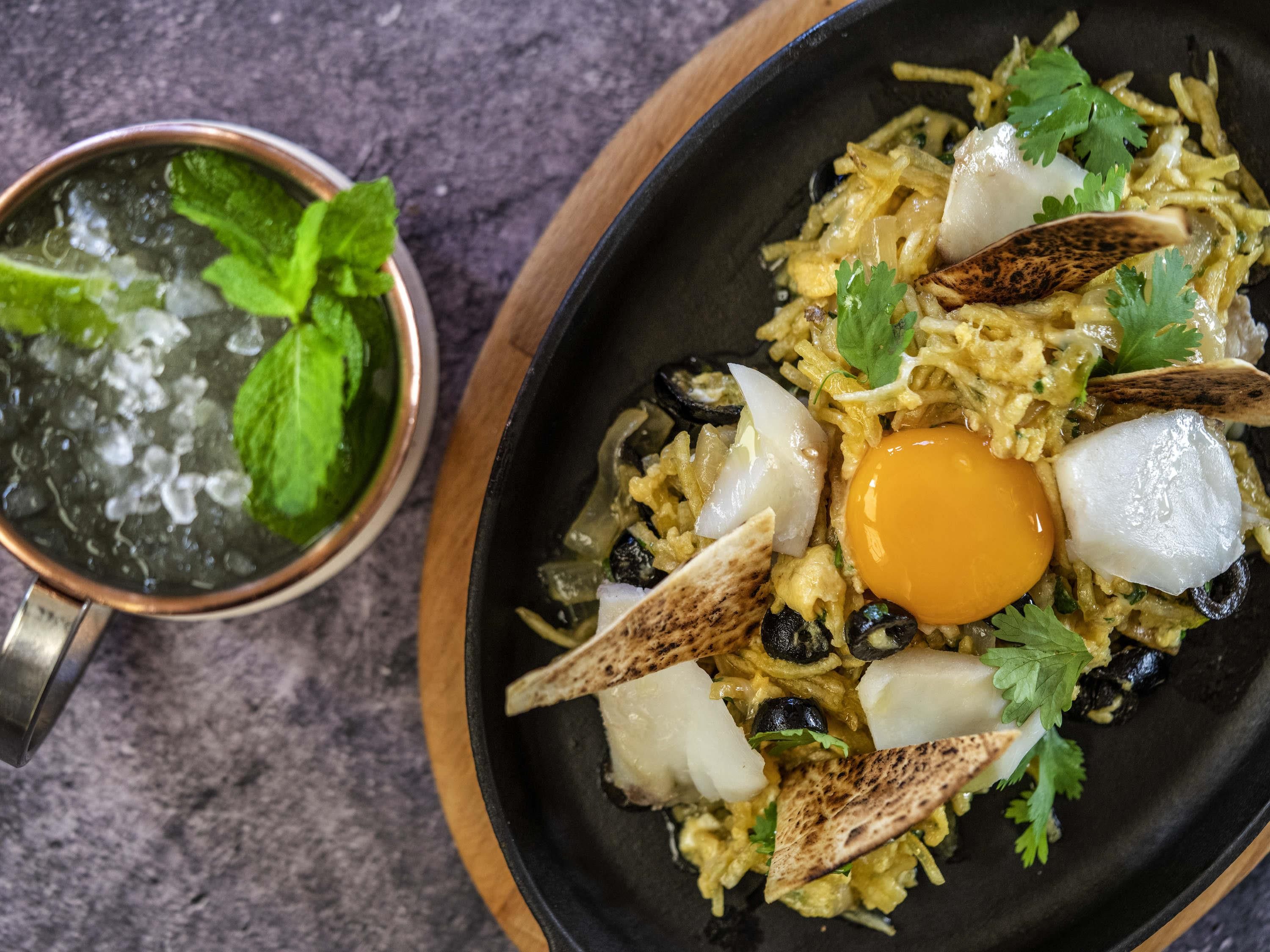 Plato con arroz, huevo y vegetales, acompañado de un costadillo de madera.