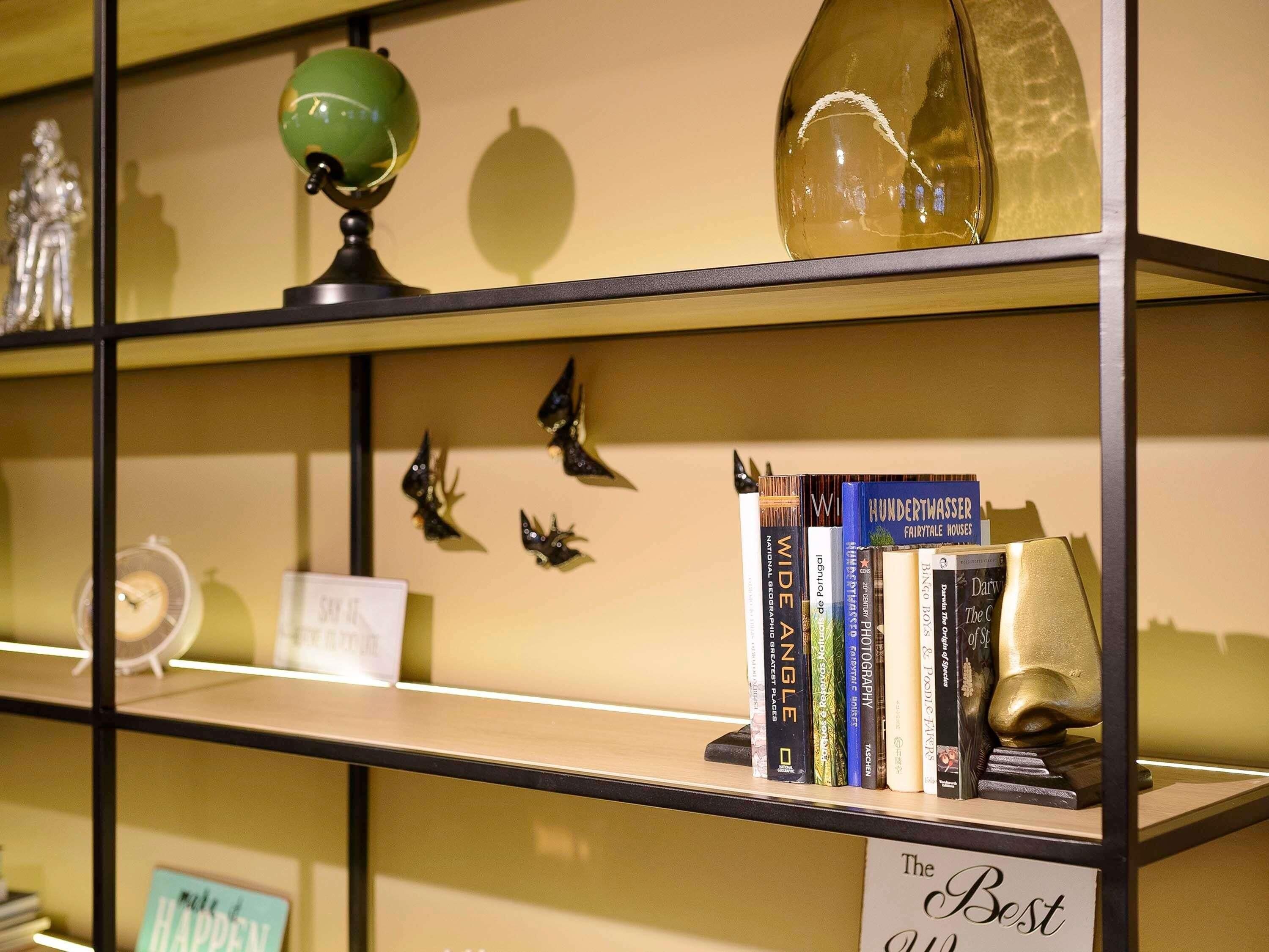 Una estantería con varios libros y objetos decorativos.
