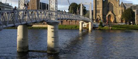 A bridge over a river with a church in the background.