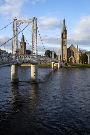 A bridge over a river with a church in the background.