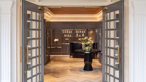 Une entrée imposante avec un plafond en bois et une table ronde centrale décorée de fleurs.