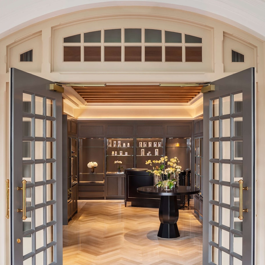 A grand entrance with a wooden ceiling and a central round table with flowers.