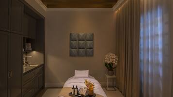 A modern bedroom with a large bed, a small bedside table with a vase of flowers, and a built-in wardrobe.