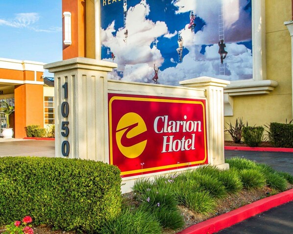 Welcome to the Clarion Hotel, situated in a well-maintained area with beautifully trimmed bushes.