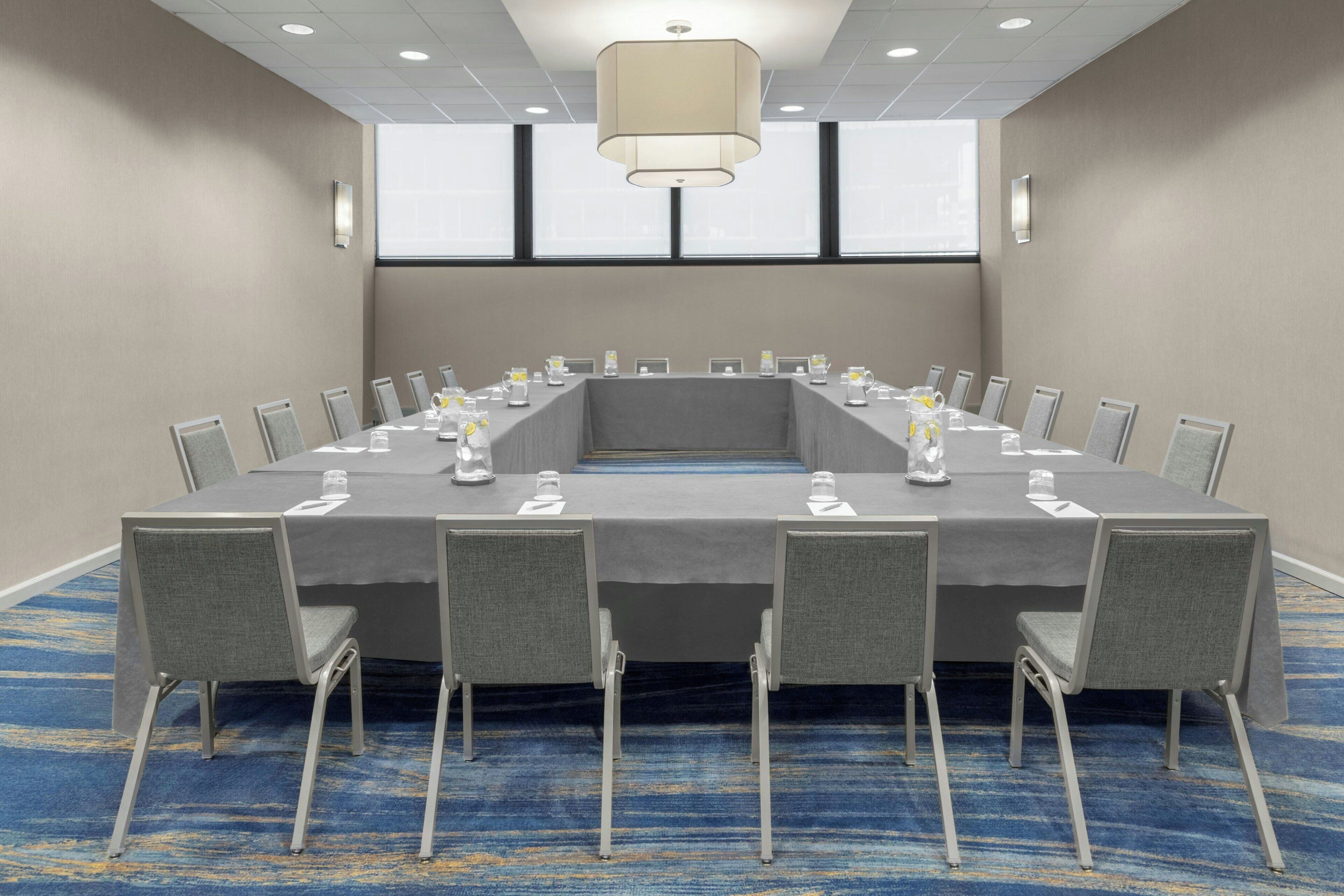 A conference room with a long table, chairs, and a chandelier.