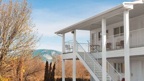 Un bâtiment blanc doté d’un porche abrité et d’un escalier menant à un étage supérieur.