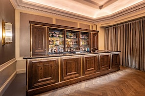 A bar area with wooden cabinets and shelves stocked with bottles. - InterContinental Edinburgh The George by IHG (Edinburgh)