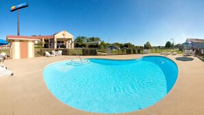 A swimming pool with lounge chairs and a building with a 'Curry's Inn' sign. - Quality Inn Reidsville Hwy 29 (Reidsville)
