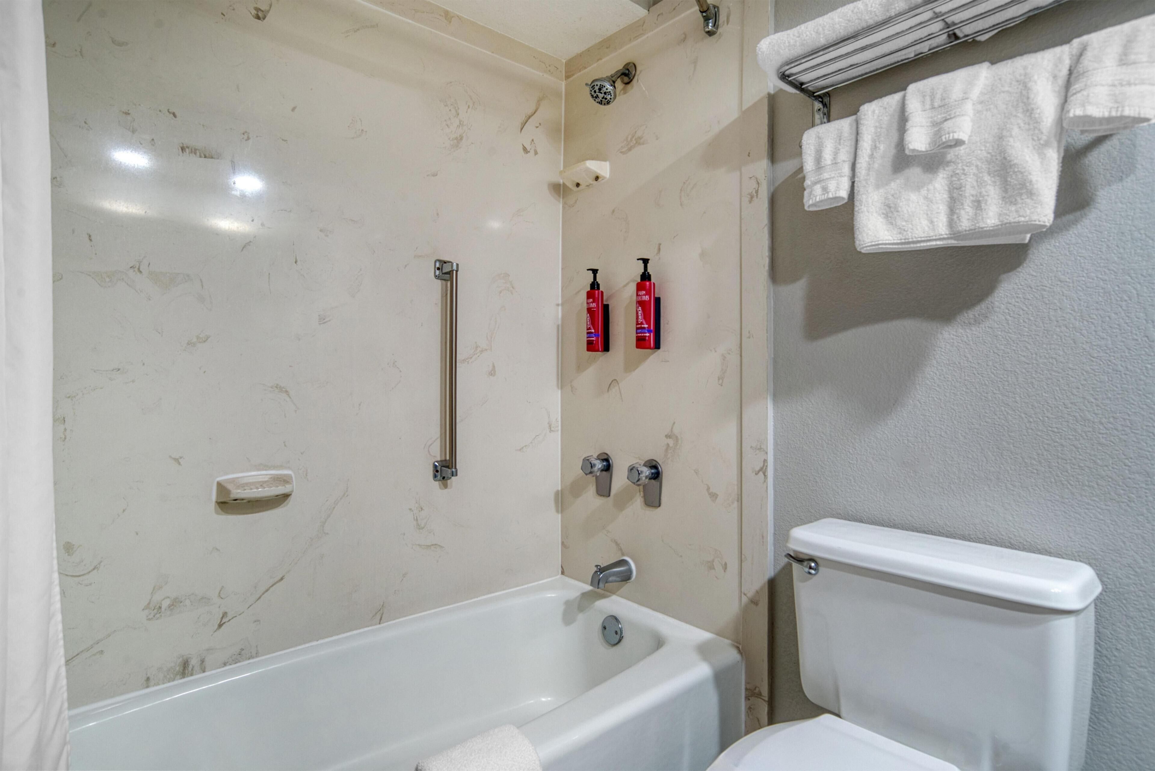 Un baño con bañera, inodoro y perchero.