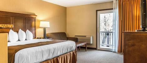 A hotel room with a large bed, a desk, a chair, a TV, and a window with curtains.