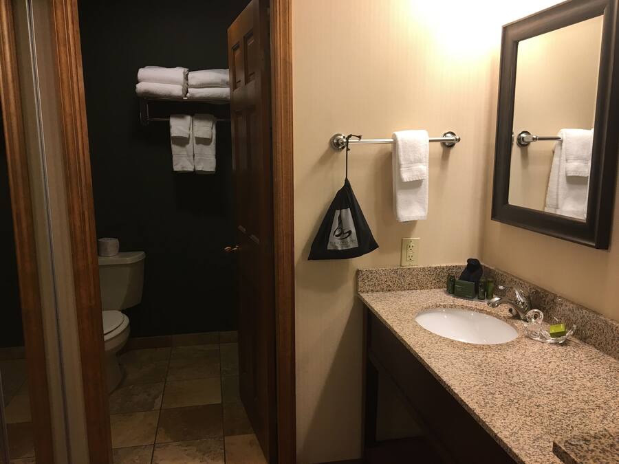 Un baño con inodoro, lavamanos y perchero para toallas.