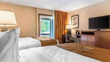 Une chambre d’hôtel avec deux lits, un bureau, une télévision et une fenêtre avec des rideaux.