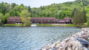A lodge with a large building and a dock by a lake, surrounded by forest. - The Black Swan Lee - Lenox, an Ascend Collection Hotel (Lee)