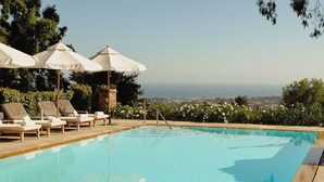 A pool area with lounge chairs and umbrellas, overlooking a scenic view. - El Encanto Santa Barbara (Santa Barbara)