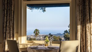 A dining table set for two with a view of the ocean and hills. - El Encanto Santa Barbara (Santa Barbara)