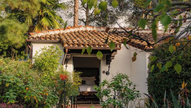 A small building with a tiled roof surrounded by lush greenery and flowering plants. - El Encanto Santa Barbara (Santa Barbara)