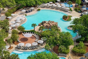 A large outdoor swimming pool surrounded by lounge areas with umbrellas and sun loungers. - Grand Hotel Golf Resort & Spa, Autograph Collection (Fairhope)