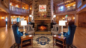 A spacious lobby with a stone fireplace, wooden floors, and a high ceiling. - Grand Hotel Golf Resort & Spa, Autograph Collection (Fairhope)