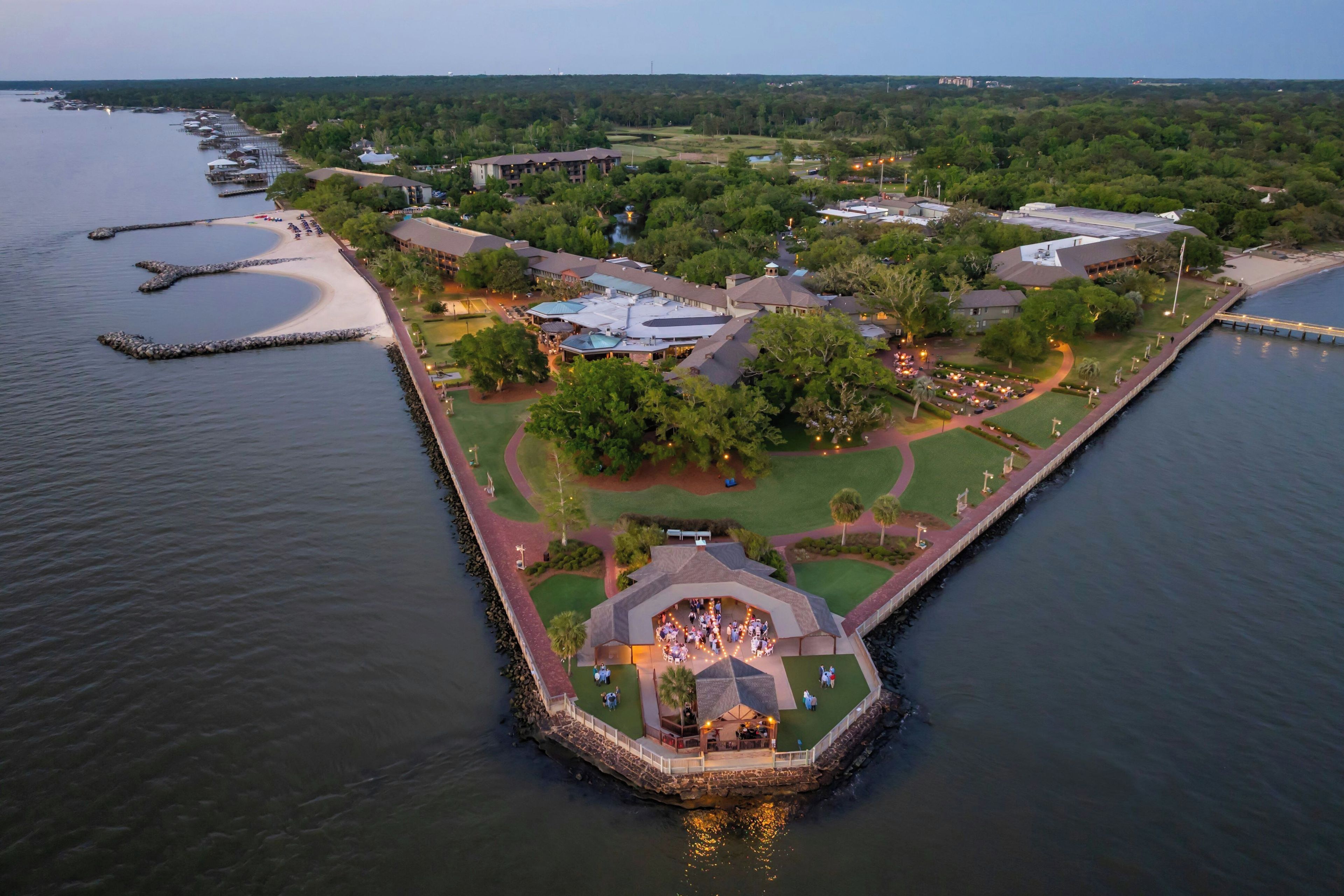 An aerial view of a waterfront property with a central courtyard, multiple buildings, and a dock.