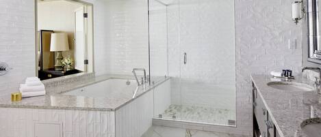 Un baño moderno con una bañera grande, una zona de ducha separada y un lavamanos.