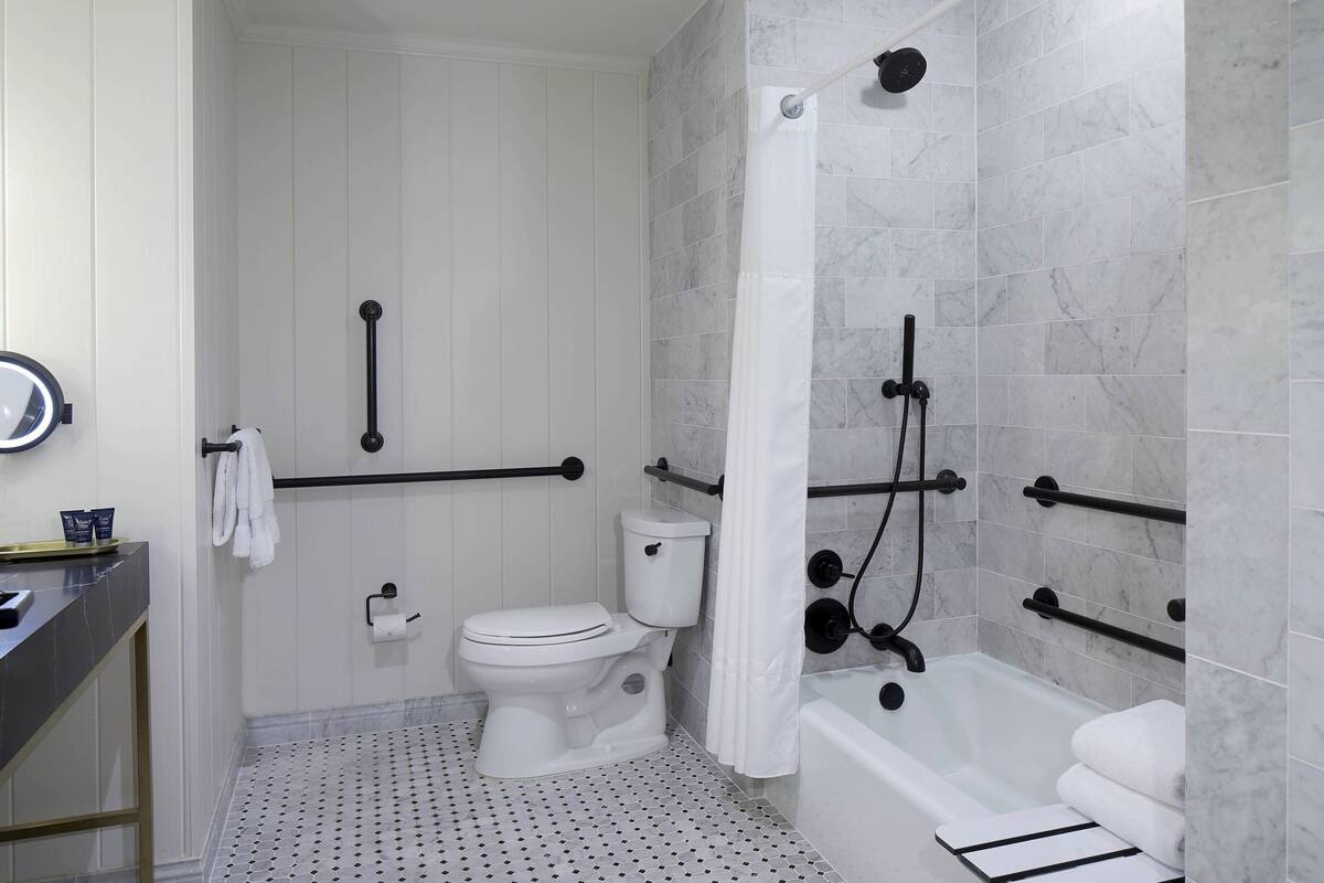 Une salle de bain comprenant des toilettes, une baignoire et une douche.