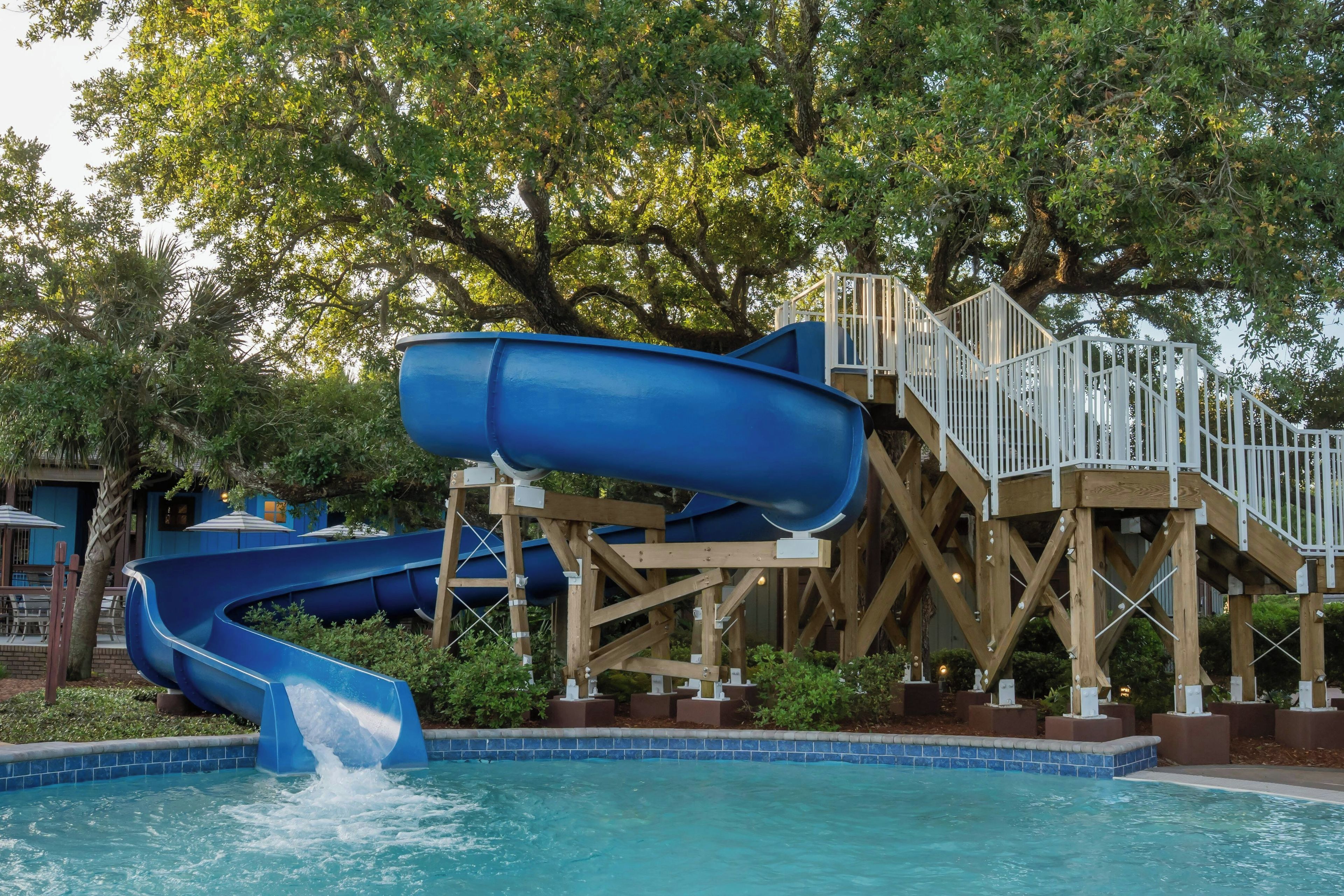 A water park with a blue water slide and a pool.