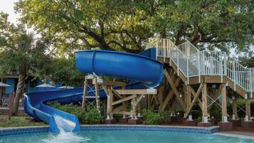 A water park with a blue water slide and a pool.