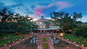 A large, circular building with a central courtyard, surrounded by trees and outdoor seating areas. - Grand Hotel Golf Resort & Spa, Autograph Collection (Fairhope)